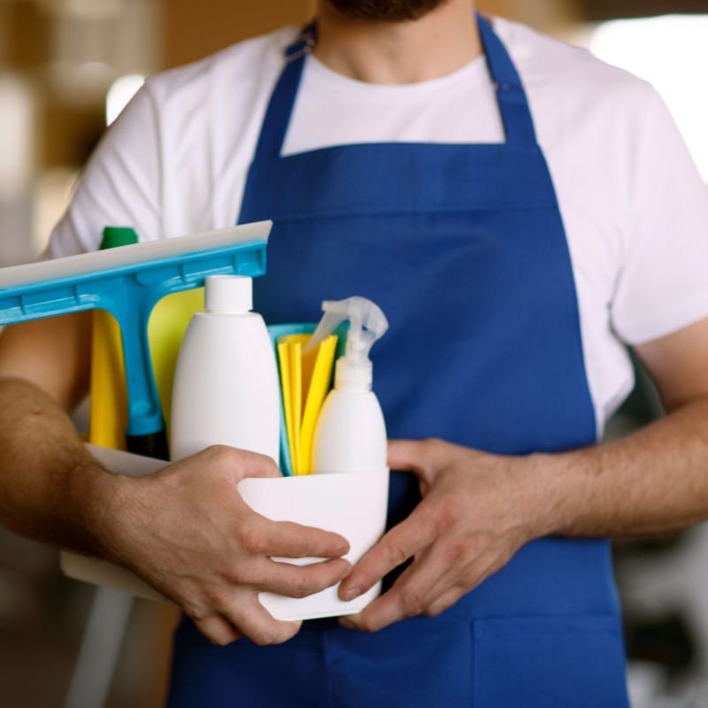 Kit de insumos de limpieza profesional sostenido por un operario de Multi Limpieza